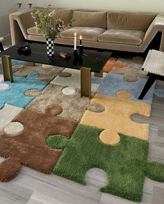 a living room with a couch, coffee table and puzzle pieces rug on the floor