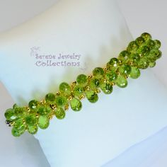 Italian made Green Peridot bead 18k yellow gold bracelet! Many 18k gold balls are scattered throughout the bracelet in between the peridot beads. A small white gold clasp completes the bracelet. There is one small 3 pointer diamond on the clasp. Total Weight: 54 grams Bracelet length: 7 inches Precious Metal: 18k yellow gold Precious stones: -Peridot Teardrops 9mmx5.2mm -White Round Diamonds: 0.03 carat, QTY 1 (on the clasp) Hallmark: 750 Elegant Lime Green Faceted Jewelry, Green Faceted Bead Bangle Jewelry, Green Faceted Beads Bangle, Elegant Peridot Round Beads Jewelry, Peridot Gemstone Beads Jewelry, Elegant Lime Green Jewelry With Round Beads, Elegant Lime Green Beaded Jewelry, Platinum Diamond Rings, Brooch Bouquets