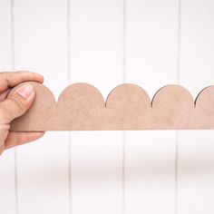 a person holding up a piece of cardboard that looks like a scallop pattern