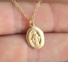 "This is a lovely little Miraculous charm necklace made of 14kt gold filled. This sacred oval pendant is 14kt gold filled, measures 14x9mm and comes on a 14kt gold filled chain with spring clasp. Choose length of 16\", 18\", 20\" or 22\". Comes in a cute gift box ready to present. *Model is wearing a 18\" length in the photo. *May be ordered and gold filled, rose gold filled or sterling silver." 14k Gold Oval Pendant Charm Necklace For Gift, Dainty Miraculous Medal Charm Necklaces As Gifts, Dainty Miraculous Medal Charm Necklace As Gift, Dainty Charm Necklaces With Miraculous Medal For Gifts, Dainty Charm Necklaces With Miraculous Medal As Gift, Dainty Oval Yellow Gold Charm Necklaces, Gold Oval Sterling Silver Charm Necklaces, Gold Oval Charm Necklaces In Sterling Silver, Gold Oval Charm Necklace In Sterling Silver