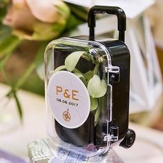 a piece of luggage sitting on top of a table filled with money and flowers in the background