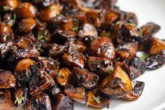 a plate full of cooked mushrooms on a table