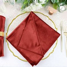 a place setting with red napkins and silverware