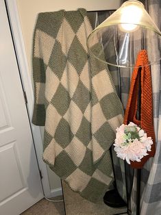 a green and white checkered blanket next to a lamp