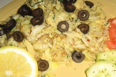 a yellow plate topped with rice and veggies next to sliced oranges on a table