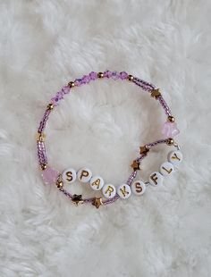 a beaded bracelet with the word sparkle written in white letters and beads on it