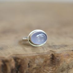 Soft, natural, blue Chalcedony is absolutely elusive and breathtaking here in this minimal, East-West Oval, .925 Sterling Silver Ring. If you love blue chalcedony, the quality here is lovely. Beautiful, Soft blue chalcedony is highlighted by the modern sterling silver design. All traditional Silversmithing techniques done in our Baltimore, MD studio Blue Chalcedony AA - 10x14mm Ring Top measures 13x17mm All .925 Sterling Silver Chalcedony is a nurturing stone that promotes brotherhood and good will. It absorbs negative energy. It brings the mind, body, emotions and spirit into harmony. At Linda Blackbourn Jewelry, I've tried my best to describe everything as accurately as possible -- in words and photos. Gemstones vary, of course, as do computer monitor screens, so there may be minor discr Blue Moonstone Rings With Natural Stones, Modern Blue Moonstone Gemstone Ring, Modern Blue Moonstone Ring, Modern Chalcedony Jewelry With Polished Finish, Blue Minimalist Moonstone Promise Ring, Blue Moonstone Cabochon Ring, Fine Jewelry Chalcedony Gemstone Rings, Oval Chalcedony Rings Fine Jewelry, Blue Oval Amethyst Ring In Sterling Silver