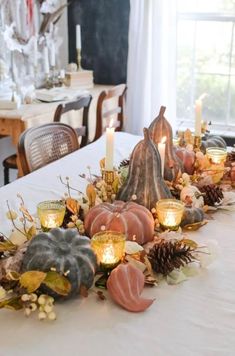 the table is set with candles, pumpkins and other decorations