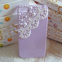 there is a purple case with pearls on it and some boxes in the back ground