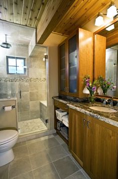 a bathroom with wooden cabinets and marble counter tops