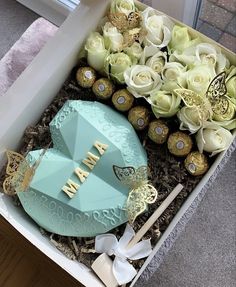 a box filled with lots of white flowers and chocolate covered cakes in it's center