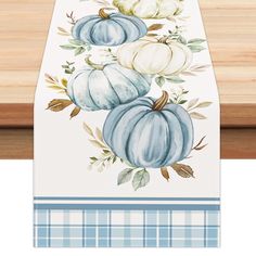 a table runner with blue and white pumpkins on it