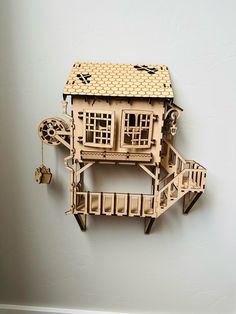 a paper model of a house on the wall with a clock and wind indicator attached to it