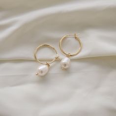 An everyday minimalistic hoop. This earrings is perfect for all day wear and is perfect for the gym, going out, or just a casual day. A classic simple gold hoop with a fresh water pearl.  D E T A I L S - 15 mm 18k gold plated hoop. - One freshwater pearl. These pearls are genuine and real, appearance with vary slightly! Freshwater pearls are high quality and iridescent. Each pearl will vary in shape.  - Earring hoop is gentle on the ears and feels secure.  - Comfortable to wear.  ∙ EXTRAS  - Handcrafted with a lot of love.  - All of my jewelry arrives tightly wrapped.  - If this is a special gift or if you would like a customization just let me know in the message box at checkout.  ∙ MY SHOP Check out more of my pieces - https://www.etsy.com/shop/ashlikitta?ref=simple-shop-header-name&list Cheap Elegant Small Hoop Pearl Earrings, Bridesmaid Earrings Gold Simple, Cheap Hoop Earrings With Pearl Charm For Women, Hoop Pearl Earrings, Simple Gold Earrings, Bridesmaid Earrings Gold, Earring Hoop, Earrings Everyday, Gold Dangle Earrings