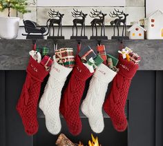 christmas stockings hanging from a mantel in front of a fireplace