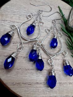 "One word: SENSATIONAL!  These chandelier earrings are stunning in every way possible! Super elegant with tons of sparkle and perfect for the holidays!  Earring deets: Using high quality bead wire I created this gorgeous pair of chandelier earrings! I adorned with royal blue faceted glass briolettes with the most remarkable sparkle. These earrings are whimsical and absolutely beautiful!  Each pair is made to order. Some slight size variations may occur with stones or frame work. These are handma Wire Wrapped Teardrop Earrings For Party, Wire-wrapped Teardrop Chandelier Earrings For Parties, Blue Teardrop Wire Wrapped Chandelier Earrings, Teardrop Wire Wrapped Chandelier Earrings For Parties, Teardrop Wire Wrapped Crystal Earrings For Party, Wire Wrapped Teardrop Chandelier Earrings For Party, Frame Work, Pine Cone Art, Blue Beaded Earrings