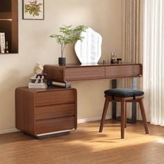 a desk and chair in a room with wood floors, white walls and curtains on the windowsill