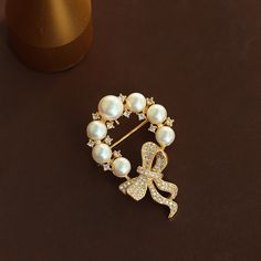 Indulge in the ultimate sophistication with our Copper Round Pearl Bow Brooch. Made with luxurious copper and adorned with a delicate round pearl, this brooch adds a touch of elegance to any outfit. The intricate bow design evokes a sense of timeless beauty, making it the perfect accessory for any occasion. Elevate your style with this exclusive piece.      Tarnish proof    Water proof    Sleep / Nap proof    Safe for sensitive skin    Wear it while working out &showering    Designed to wear 24/ Elegant Round Brooch For Anniversary, Elegant Round Brooches For Anniversary, Elegant Brooches With Decorative Bow For Anniversary, Elegant Pearl Brooches For Formal Occasions, Elegant Gold Brooches For Party, Elegant White Pearl Brooches, Gold Wedding Brooches Chic Style, Gold Wedding Brooches In Chic Style, Elegant Anniversary Brooch With Decorative Bow