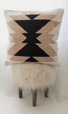 a black and white pillow sitting on top of a stool