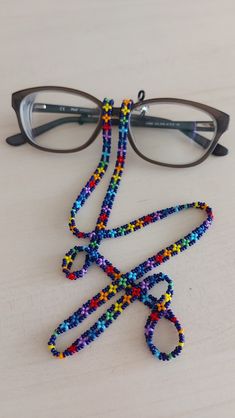 a pair of glasses sitting on top of a table next to a string of beads