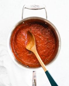 a wooden spoon in a saucepan on a white surface