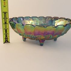 a glass bowl sitting next to a measuring tape