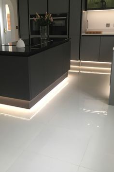 a kitchen with white floors and black cabinets