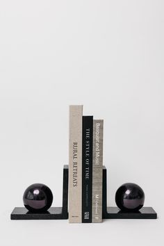 two bookends with black balls sitting on top of each other in front of a white background