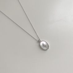 Introducing our Graceful Tulip Pendant 925 Sterling Silver Necklace, a perfect blend of a pendant necklace and flower necklace, available in both silver and gold variants. This exquisite piece makes a great gift for her or even an endearing gifts for mom, featuring a radiant gold/silver-toned 925 pure silver oval pendant with a wave-like pattern, set against a luminous white mother-of-pearl backdrop. The pendant is adorned with a delicate (18k gold-plated) 925 sterling silver tulip, adding a tou Mother Of Pearl Pendant Necklace, Elegant Silver Tarnish Resistant Necklaces, Delicate Silver Charm Necklace With Flower, Dainty Silver Charm Necklace With Oval Pendant, Dainty Silver Charm Necklace With Flower Pendant, Elegant Oval Pendant Necklaces With Flower Charm, Feminine Sterling Silver Necklace With Clavicle Chain, Silver Clavicle Chain Necklace With Oval Pendant, Silver Oval Pendant Necklace With Clavicle Chain