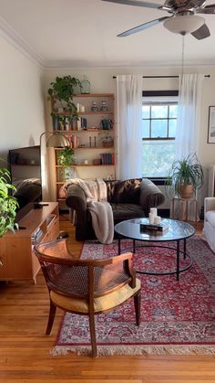 a living room filled with furniture and a ceiling fan