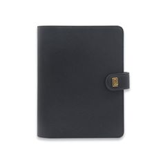 a black leather notebook with a gold logo on the front and side, sitting against a white background