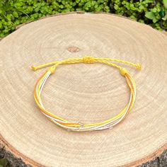 Handmade bracelet from waxed cord in yellow tones, combined with white strands and decoration of small silver lined seed beads. The bracelet fastens with a sliding knot so you can adjust the size to fit perfectly. Minimum diameter when it's closed is 15-16cm. and the fastening threads allows it to be opened to around 28-30cm. The waxed cord thickness is 1mm. If you need specific size please let us know, custom orders are welcome, feel free to contact us with any questions. All of our bracelets are 100% handmade, we don't sell anything that is not crafted by us. Created with love for you! White Waxed Cord Friendship Jewelry, White Braided Bracelets With Adjustable Length, White Braided Bracelet With Adjustable Length, White Friendship Bracelet With Sliding Knot And Waxed Cord, Adjustable White Friendship Bracelets, White Braided Bracelets With Adjustable Waxed Cord, White Friendship Bracelets With Sliding Knot In Waxed Cord, White Braided Bracelet With Adjustable Waxed Cord, Adjustable Yellow Bracelet For Friendship