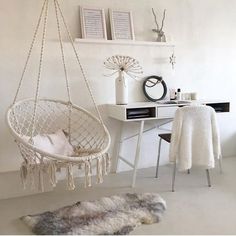 a white room with a chair, desk and hanging hammock