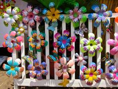 colorful paper flowers are on the back of a bench