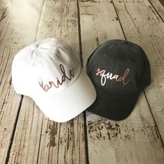 two hats sitting on top of a wooden floor next to each other, one with the word bride written on it