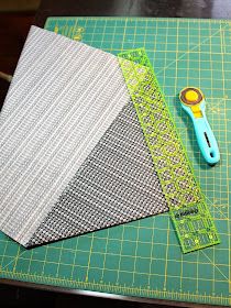 a pair of scissors sitting on top of a green cutting board next to some fabric