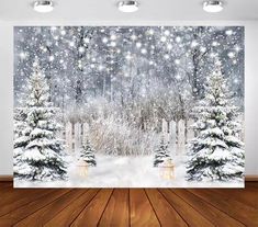 a snowy scene with christmas trees and lights on the wall, in front of a wooden floor