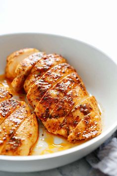 three pieces of grilled chicken in a white bowl