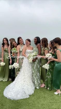 a group of women standing next to each other on top of a lush green field