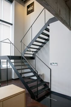 a black and white stair case next to a wall with a sign that says mm on it