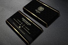 two black and gold business cards sitting on top of a table next to each other