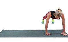 a woman is doing push ups on a mat