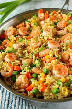 a pan filled with shrimp and rice on top of a table