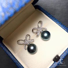 Highline: Beautiful Diamond Bow Product Information OriginTahitian Pearl Jewelry Processed in Japan MaterialTahitian Pearl, 18k White Gold and Diamond Dimensions1.3 x 1.8 cm Pearl Shaped: Round Size: 9-10mm Quality: AAAA Nacre: Very Thick Color: Platinum Grey Luster: Very High Accessories Metal: 2.7g of 18k White Gold Other: 0.46ct of SI Quality Natural Diamond Luxury Black Pearl Earrings Gift, Luxury Black Pearl Earrings For Gift, Luxury Tahitian Pearl Earrings In White Gold, Luxury Tahitian Pearl Earrings For Gift, Luxury Tahitian Pearl Earrings Gift, Luxury Silver Tahitian Pearl Earrings, Luxury Tahitian Pearl Earrings For Anniversary, Luxury Tahitian Pearl Wedding Earrings, Luxury Black Tahitian Pearl Earrings