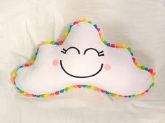 a cloud pillow with a smiley face drawn on it