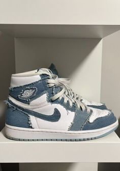 a pair of blue and white sneakers sitting on top of a shelf