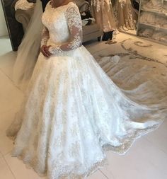 a woman standing in front of a wedding dress