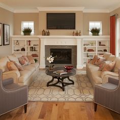 a living room filled with furniture and a flat screen tv mounted above the fire place