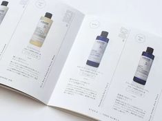 an open book with three bottles of skin care products in it's pages, on top of a white surface