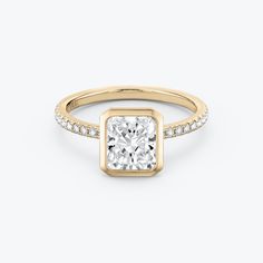 a yellow gold engagement ring with a square cut diamond in the center and pave set diamonds around the band